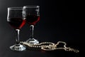 Beautiful Pearl Necklace and Two Glass Cups of Red Wine Isolated on Black Royalty Free Stock Photo