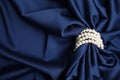 Beautiful pearls with dark blue silk as background, space for text