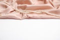 Beautiful pearls and pink silk on white background Royalty Free Stock Photo