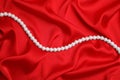 Beautiful pearls on red silk, top view Royalty Free Stock Photo