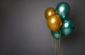 Beautiful pearly golden and green metallic inflated air balloons, isolated over gray background with copy space for advertising. Royalty Free Stock Photo