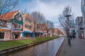 Beautiful pedestrian street in a town with colorful houses. Specific Dutch water channels on the side of the alleys in the city Royalty Free Stock Photo