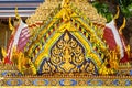Beautiful pediment of a Buddhist temple decorated with golden images of the Buddha