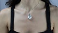 Beautiful pendant with natural baroque pearl on the neck of a young woman