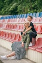 beautiful pensive mother and son hugging and looking away while sitting together