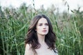 Beautiful pensive woman outdoors on green leaves and grass background in spring park Royalty Free Stock Photo