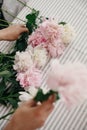 Beautiful peonies in girl hands. Florist arranging peony flowers on rustic table. Happy mothers day. Valentines day. Aroma scent