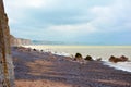 Beautiful peppel beach, sea with golden light reflections and chalk cliffs in far distance in Normandy, France