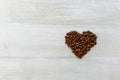 Beautiful shot of the coffee mug in the morning on the white wooden table with coffee heart shaped beans. Perfect for copy valent