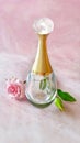 Beautiful perfume bottle and rose flower on marble background