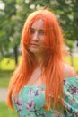 Pretty redheaded girl walking in the summer park