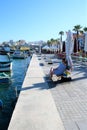 Marsaxlokk, Malta, August 2019. Woman resting on the promenade in the evening.