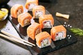 Beautiful Philadelphia Sushi Rolls Set with Salmon and Cream Cheese and Cuccumber on Black Slate Plate Close Up. Uramaki, Nori Mak Royalty Free Stock Photo