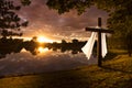 Beautiful photo illustration of an Easter morning sunrise on a cross by a calm lake