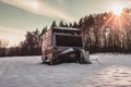 Beautiful photo of old and abandoned caravan in the middle of snow covered meadow in Winter time. Illuminated Caravan campervan