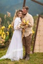 beautiful photograph captures the tender embrace of a couple at their humanist wedding ceremony. The bride is holding a lovely