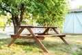 Beautiful picnic area with wooden table in sunny autumn garden. Resting place on park. Picknick place in summer Orchard. Wooden pi Royalty Free Stock Photo