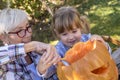 Beautiful picture of a grandmother with her grandchild making a Halloween pumpkin