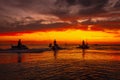 Beautiful picture of people riding water scooters against a mesmerizing orange sunset