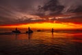 Beautiful picture of people riding water scooters against a mesmerizing orange sunset