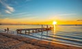 Beautiful picture of a vintage wooden bridge in an ocean against a mesmerizing sunset