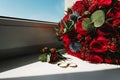 Beautiful picture with wedding rings lie on a wooden surface against the background of a bouquet of flowers Royalty Free Stock Photo