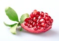 A beautiful piece of juicy young pomegranate with a pomegranate branch with green fresh leaves isolated on a white background. Royalty Free Stock Photo