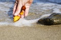 Beautiful pieces of amber in the hand of the sea background. A glowing wavy piece of amber in the palm of your hand. The