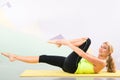 Beautiful pilates instructor with yellow yoga mat