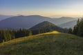 On a sunny summer day, the view from the plateau to the forest and mountains. Blue sky, lots of green grass and trees. Royalty Free Stock Photo