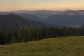 On a sunny summer day, the view from the plateau to the forest and mountains. Blue sky, lots of green grass and trees. Royalty Free Stock Photo