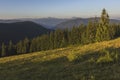 On a sunny summer day, the view from the plateau to the forest and mountains. Blue sky, lots of green grass and trees. Royalty Free Stock Photo