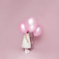 Beautiful pink birthday card background. Little baby girl holding rose balloon Royalty Free Stock Photo