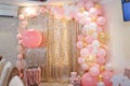 Beautiful pink decorations, wrapped present boxes with ribbons and bow, flowers and balloons on golden shiny background. Royalty Free Stock Photo