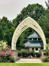 White metal arch with stone and concrete bases in garden Royalty Free Stock Photo