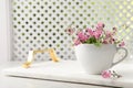 Beautiful pink forget-me-not flowers with cup on light stone table. Space for text