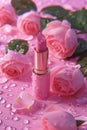 Beautiful pink lipstick and pink rose flowers with water drops on pink background Royalty Free Stock Photo