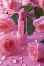 Beautiful pink lipstick and pink rose flowers with water drops on pink background Royalty Free Stock Photo