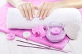 Beautiful pink manicure with orchid, candle and towel on the white wooden table. Royalty Free Stock Photo