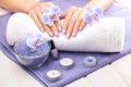 Beautiful pink manicure with orchid, candle and towel on the white wooden table. Royalty Free Stock Photo