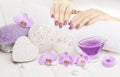 Beautiful pink manicure with orchid and towel on the white wooden table. spa Royalty Free Stock Photo