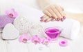 Beautiful pink manicure with orchid and towel on the white wooden table. spa Royalty Free Stock Photo