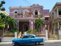 Beautiful pink purple house and blue car in Havana Cuba