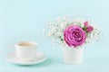 Beautiful pink rose flower and gypsophilla in vase and cup of coffee on turquoise vintage table for cozy breakfast. Royalty Free Stock Photo