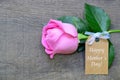 Beautiful pink rose with Happy MotherÃÂ´s Day tag card on wooden background. Mothers Day festive concept with copy space. Royalty Free Stock Photo