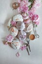 Beautiful pink, rose peonies decorated with tasty meringues on white wood table Royalty Free Stock Photo