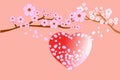 Love and wedding concepts. Full bloom cherry blossoms and blowing/flying petals on red heart shape; old-rose colored background.