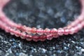 Beautiful pink strawberry quartz beads on a black glitter background close-up macro photo Royalty Free Stock Photo