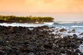 Beautiful pink tinted waves breaking on a rocky beach at sunrise on east coast of Big Island of Hawaii Royalty Free Stock Photo