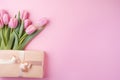 Beautiful pink tulips flowers and present. Romantic gift wallpaper with space for text. Light gentle pink color bouquet